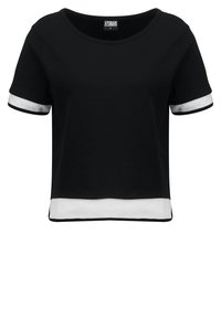 T-shirt nera a maniche corte, cropped, con accenti in rete bianca sulle maniche e sull'orlo. Tessuto liscio; scollatura rotonda.