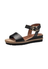 Sandale en cuir noir avec une large sangle au niveau des orteils, une sangle de cheville avec boucle réglable et une semelle intérieure en liège. Dispose d'un petit talon compensé et d'une semelle extérieure texturée.