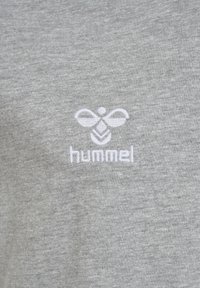 Grå bomulds t-shirt med et hvidt broderet logo med et bi-design og ordet "hummel" nedenfor. Blød tekstur, afslappet stil.