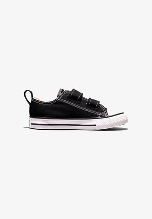 Czarny niskoprofilowy sneaker z białą gumową osłoną na palce, dwoma paskami na rzep, białym przeszyciem, pętelką do ściągania i białą podeszwą z czarnymi paskami.