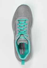 Grå och turkos sportskor med turkosa snören, prickig innersula och "Skech-Knit"-etikett på tungan.