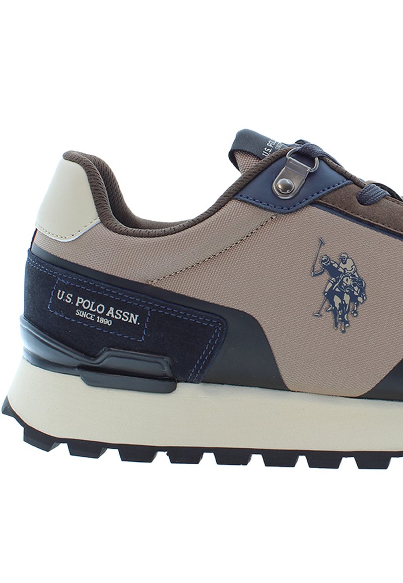 Sneaker beige e navy di U.S. Polo Assn. con logo di due giocatori di polo a cavallo e suola nera robusta.
