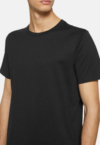 T-shirt in cotone nero con colletto rotondo, maniche corte e un discreto dettaglio del logo sul petto. Tessuto morbido con una vestibilità classica.