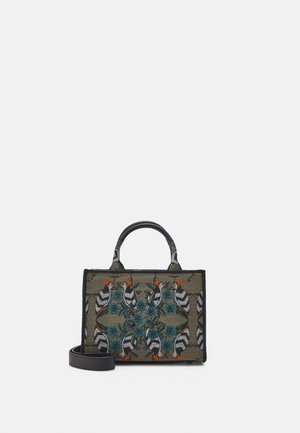 Tote bag med en rektangulær form, der har et tekstildesign med fugle og blomster i blå, orange og sort på en grøn baggrund. Sorte håndtag og rem.