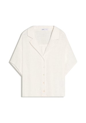 Kortærmet, løs hvid linskjorte med reverskrave og knaplukning foran, vist fladt på hvid baggrund.