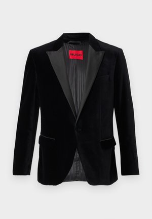 Black velvet blazer with a satin lapel, single-button closure, two front pockets, and a lined interior featuring a red brand label.
