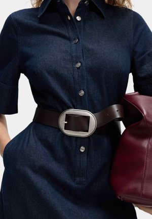 Dunkelblaues Denim-Kleid mit kurzen Ärmeln und Knopfverschluss, tailliert mit einem breiten braunen Leder-Gürtel mit einer großen Metall-Schnalle.