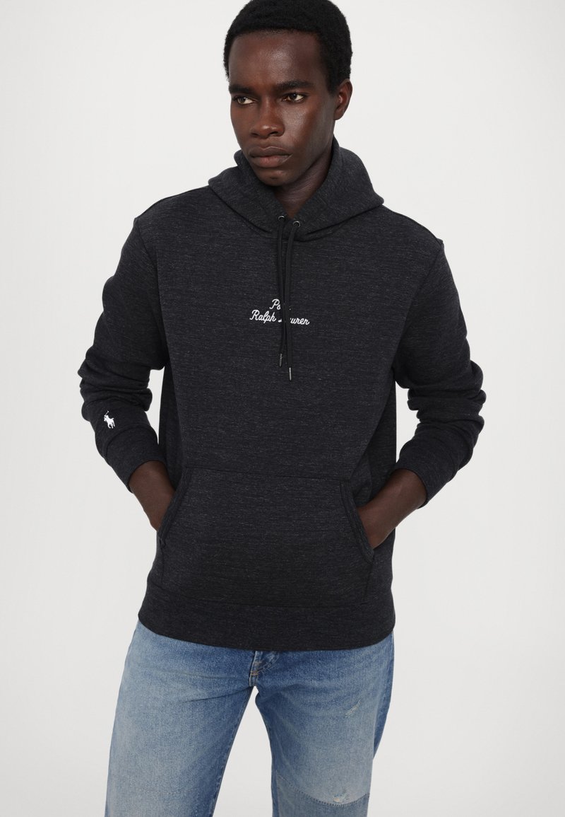 Dunkelgrauer Baumwoll-Hoodie mit Kordelzug, Fronttasche und weißem, gesticktem Logo auf der Brust und dem Ärmel. Klassische Passform.