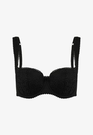 Black lace bra with structured cups, decorative scalloped edges, adjustable straps, and a small central bow accent.