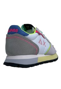 Multikleur sneaker met grijs suède, witte en neonaccenten, gelaagde materialen, een gestructureerde zool en een merklabel aan de hiel.