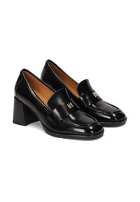 Mocassins à talons blocs en cuir verni noir avec une large sangle et un accent logo doré. Surface lisse avec un design à bout rond.