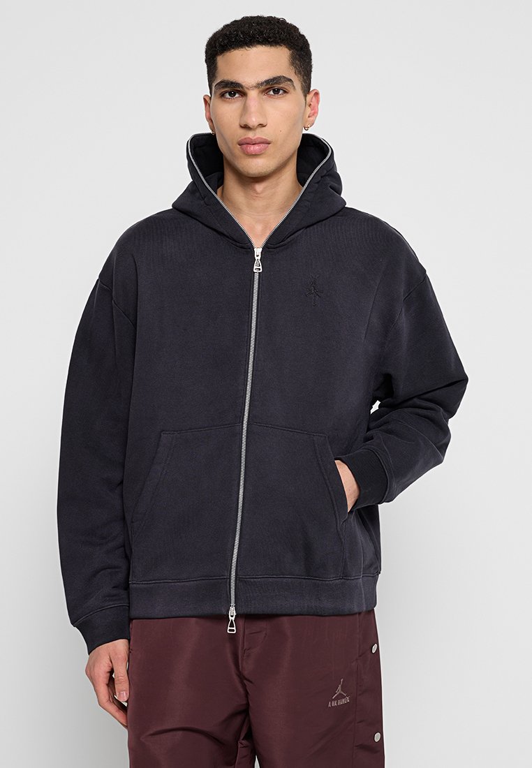 Dunkelgrauer Reißverschluss-Hoodie mit Kängurutasche, gerippten Bündchen und Kapuze. Dezentes Logo-Detail auf der Brust, weicher Stoff.