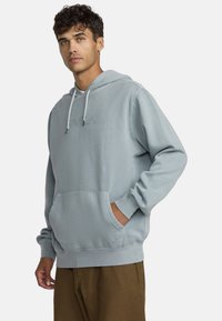Hellblaue Kapuzenjacke mit einer vorderen Kängurutasche, verstellbarem Schnürzug an der Kapuze, gerippten Bündchen und einem dezenten, geprägten Logo auf der Brust.
