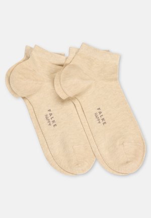 Beiget nilkkasukat, joissa on resorit, ja joissa lukee "FALKE HAPPY", esitettynä pinottuna parina valkoisella taustalla.