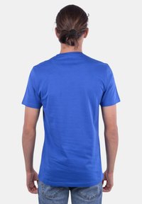 T-shirt blu a maniche corte realizzato in cotone morbido, caratterizzato da un classico collo tondo e un design semplice senza grafiche o decorazioni.