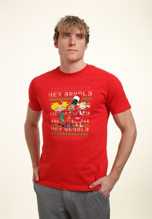 Czerwona bawełniana koszulka z grafiką przedstawiającą animowane postacie oraz napisem "HEY ARNOLD" w pogrubionym tekście, na tle dekoracyjnego wzoru.
