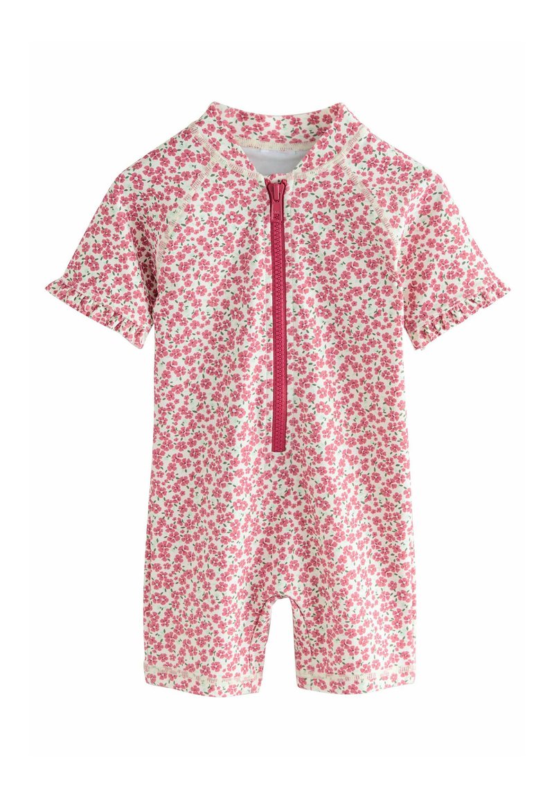 Kortärmad, rosa blommig jumpsuit med en dragkedja fram, gjord av mjukt tyg. Rynkiga ärmar och knälång design, med små gröna accenter.