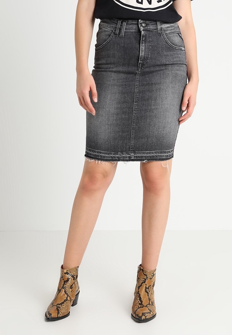 Černá denimová tužková sukně s třásněmi na lemu, vysokým pasem a designem s pěti kapsami, kombinovaná s hnědými kotníkovými botami s hadím vzorem.
