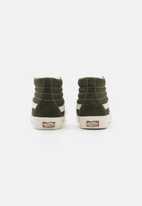 Sneakers verde alta con esterno in tessuto morbido, striscia laterale bianca e collo imbottito. Suola in gomma con dettaglio del logo sul tallone.
