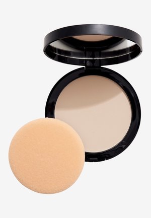 Compact poeder in een zwarte doos met een spiegel, bevat een beige perspoeder en een ronde, zachte perzikkleurige applicatorspons.