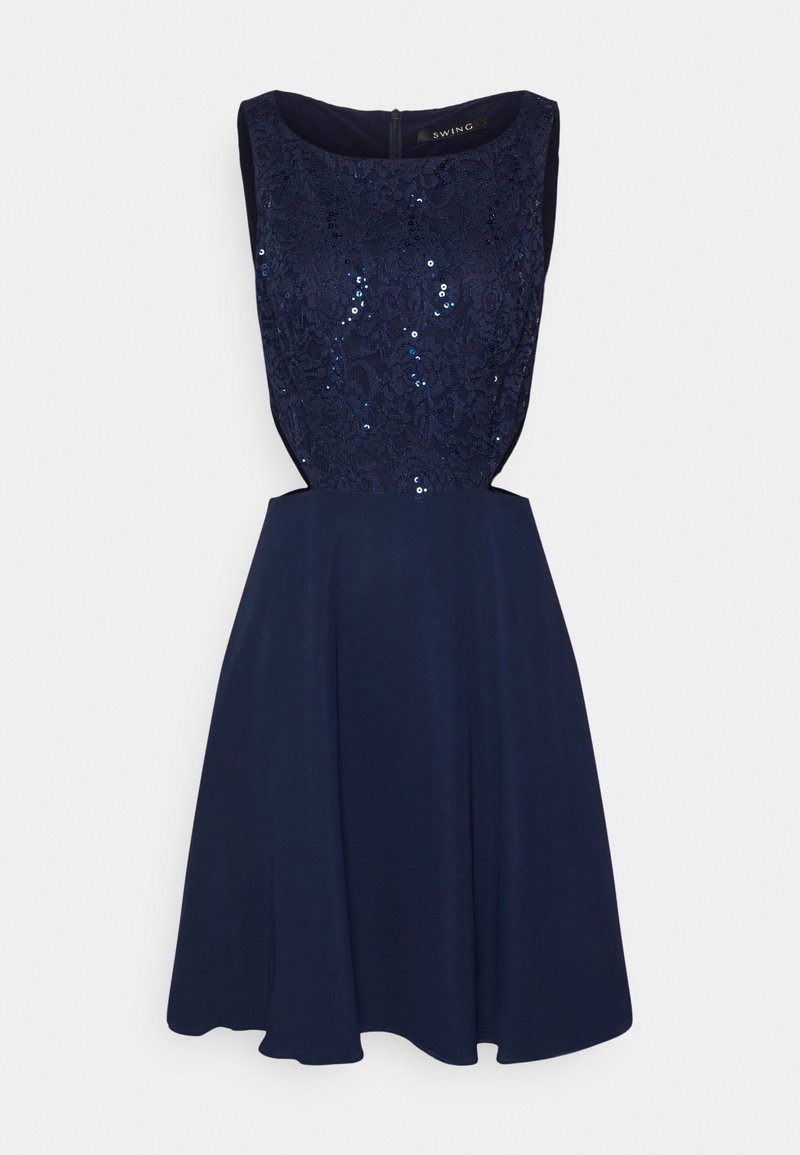 Robe sans manches bleu marine avec dentelle et sequins sur le corsage ajusté et une jupe évasée, avec des découpes sur les côtés et une fermeture éclair au dos.