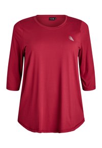 Punainen pitkähihaisen paita, jossa on pyöreä kaula-aukko ja kaareva helma, valmistettu sileästä kankaasta. Paidassa on pieni valkoinen graafinen yksityiskohta rinnassa.