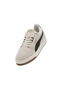 Baskets en suede beige avec une bande latérale noire et des accents de logo dorés. Présente une languette rembourrée et une semelle texturée pour une meilleure adhérence. Zone des orteils perforée.