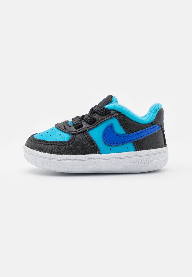 Schwarz-blauer Kleinkind-Sneaker mit weißer Sohle, schwarzen Schnürsenkeln und blauem Nike-Swoosh-Logo an der Seite.