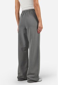 Gray wide-leg pants with an elastic waistband, made of soft fabric, featuring a smooth texture and a relaxed fit.