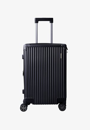 Maleta rígida negra con estrías verticales, asa telescópica extendida y cuatro ruedas multidireccionales sobre un fondo blanco.