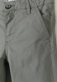 Grijze katoenmix chino's met een knoopsluiting, riemlussen, zijzakken en subtiele stikdetails. Soepele textuur met een casual pasvorm.