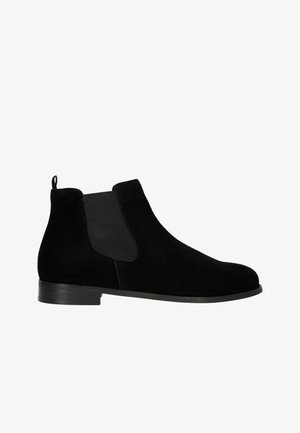 Bottes chelsea en nubuck noir avec des panneaux élastiques sur les côtés, bout rond et talon empilé noir, conçues pour un look moderne et épuré.