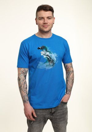 Camiseta de algodón azul con un gráfico de un caballo y una mujer en agua fluyente. Mangas cortas, cuello redondo, textura suave y corte casual.