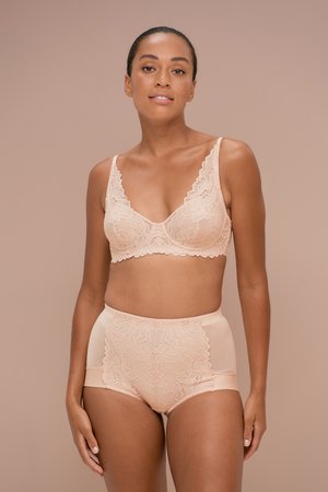 Spitzen-Bralette und hochgeschnittene Slips in sanftem Nude, mit floralen Mustern und gewellten Kanten für Textur und visuelles Interesse.