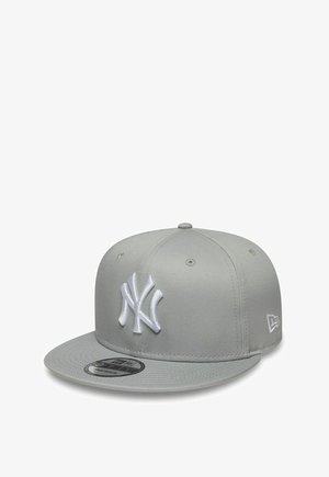 Graue Baseballkappe mit flachem Schirm, vorne mit weiß gesticktem "NY"-Logo und seitlichem New Era-Logo, mit Sticker auf dem Schirm.