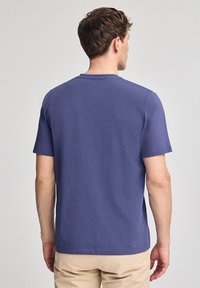 Lila crew neck t-shirt i bomull, med korta ärmar och avslappnad passform, med en mjuk textur och utan synliga mönster eller grafik.