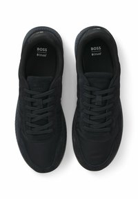 Chaussures de sport noires en mélange de tissu lisse et de daim. Design à lacets avec semelles texturées et amorti Ortholite®.