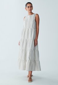 Gelaagde maxi-jurk van lichtgewicht stof met verticale blauwe en beige strepen. Voorzien van mouwloos ontwerp en afgeronde halslijn. Afgewerkt met een rucheszoom.