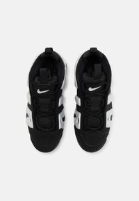 Mustvalged mustad ja valged spordijalatsid, millel on võrkpinna ülemine osa, pehmendusega kaelus, tekstureeritud tallad ja silmapaistev Nike logo külgmisel küljel.