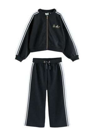 Black two-piece tracksuit with white side stripes, zip-up cropped jacket with logo, and drawstring wide-leg pants.