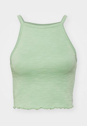 Žalias raukšlėtas trumpas topas su plonomis petnešomis, su banginiu apvadu ir tekstūruota medžiaga. Nėra išsikišusių aksesuarų ar raštų.