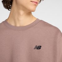 Felpa rosa chiaro con colletto a costine e logo New Balance ricamato in nero sul lato sinistro del petto. Tessuto morbido.