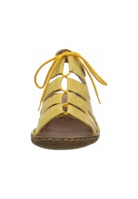 Yellow leather sandals with an open design, featuring crisscross straps, rounded toe, and a lace-up closure. Textured outsole.