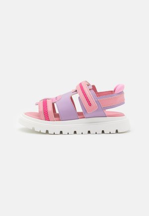Pink and lavender sandal with adjustable straps, mesh detail, and a chunky white sole. Textured upper with soft lining.
