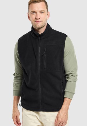 Gilet en polaire noir avec un col haut, une fermeture éclair sur toute la longueur et deux poches avant. Dispose d'une poche poitrine zippée et d'une texture douce.
