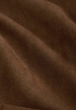 Tessuto in suede marrone con una superficie morbida e testurizzata, che mostra sottili variazioni di ombreggiatura e una finitura liscia e opaca.