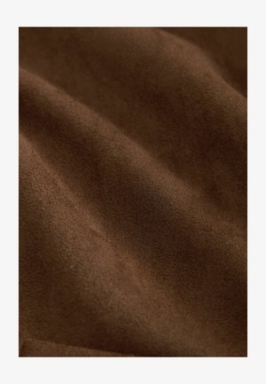 Brūnas zamšādas audums ar mīkstu, teksturētu virsmu, kurā ir smalkas krāsas atšķirības un gluda, matēta apdare.