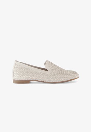 Chaussure slip-on beige avec une tige texturée, présentant un design tissé et une semelle plate couleur marron clair. Aucun matériel ni accent visible.