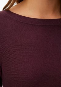 Sweter z dzianiny w głębokim burgundzie, z szerokim dekoltem i subtelną fakturą w prążki. Gładki, miękki materiał dla komfortu.