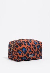 Neceser de estampado de leopardo en tonos naranjas, marrones y azules, con cierre de cremallera y un logo de la marca brillante en la parte frontal.